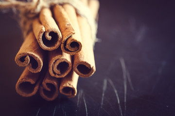 Bunch of cinnamon sticks on black background.