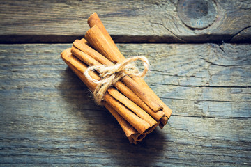 Bunch of cinnamon sticks on wooden background