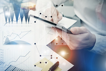 Banker manager working process.Photo analyst trader work market charts.Using electronic devices.Graphic icons,worldwide online stock exchanges interfaces on screen.Business project startup.Film effect