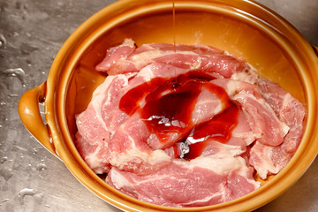Raw pork slice with oyster sauce in bowl on white background