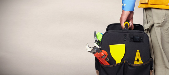 Naklejka premium Hand of handyman with a tool bag.