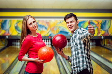 Fototapeta na wymiar Beautiful girl and young man at the bowling alley