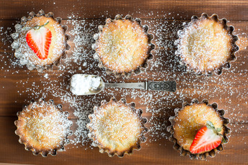 Cupcakes with strawberry and sugar powder in vintage form. Rustic style.