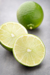 Juicy ripe lime an gray table.