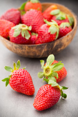 Strawberry in a bowl on the gray background.