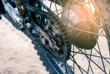 Obraz premium Old dirty motorcycle chain on wheel.