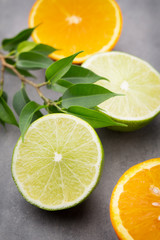 Mixed citrus fruit lemons, orange, kiwi, limes on a gray backgro