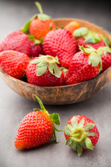 Strawberry in a bowl on the gray background.