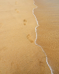 Human footprints on beach sand background