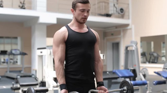 Bodybuilder shakes his biceps at the gym