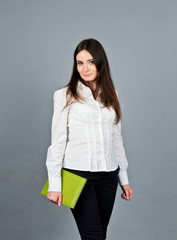 Woman in white blouse standing and keep her green notes. Business girl in white blouse. She stands in studio