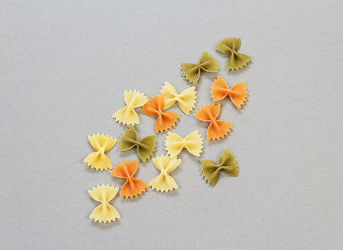 Farfalle pasta close-up on  light gray background.