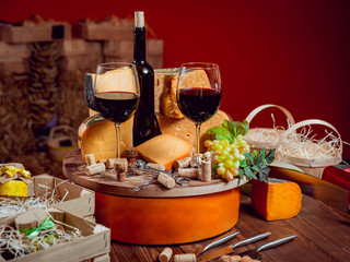 Cheese and wine on a dark table.