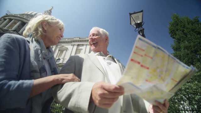  Happy mature couple in London, looking at map to get directions