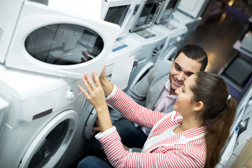 Fototapeta premium Happy family couple choosing new microwave