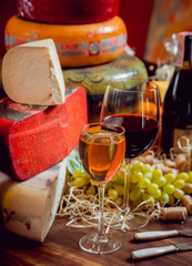 Cheese and wine on a dark table.