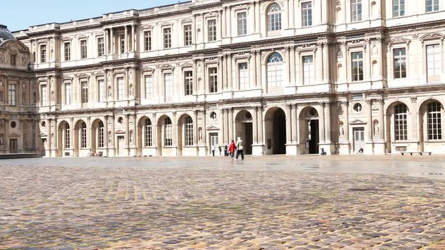 France, Paris: Louvre museum courtyard in the morning after rain, tourists, passersby, wet pavement, palace facade
