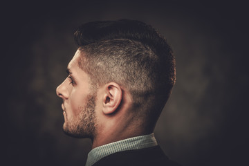 Obraz premium Serious well-dressed hispanic man posing on dark background.