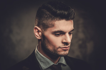 Obraz premium Serious well-dressed hispanic man posing on dark background.