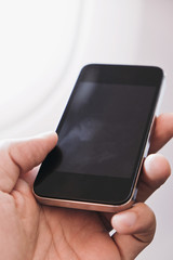 close up of business man siting near airplane window and watching his phone, Business communication