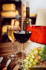 Cheese and wine on a dark table.