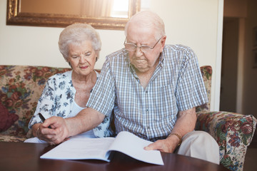 Retired couple looking over documents at home