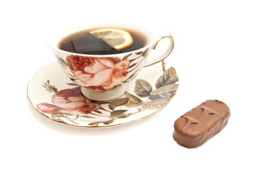 tea with lemon and chocolate bar on white