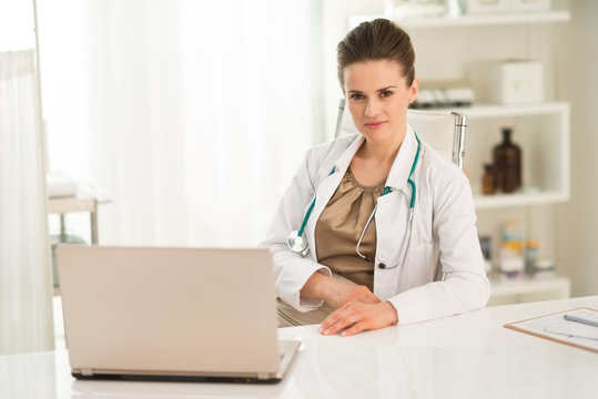Portrait of female doctor sitting at a desk in the office