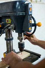 Fototapeta na wymiar Carpenter using a drill