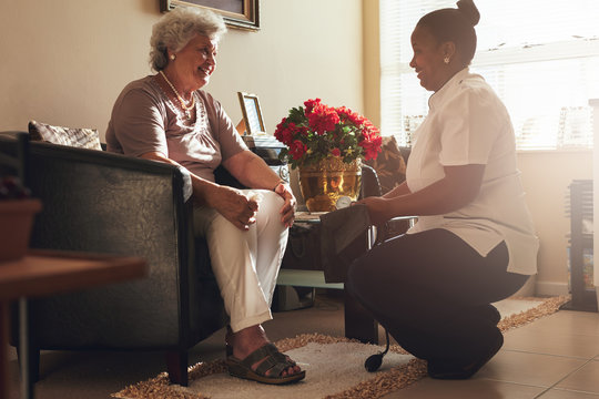 Female nurse visiting senior patient for checking blood pressure