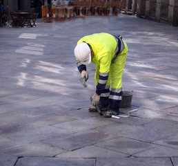 Arbeiter repariert Gehwegplatten