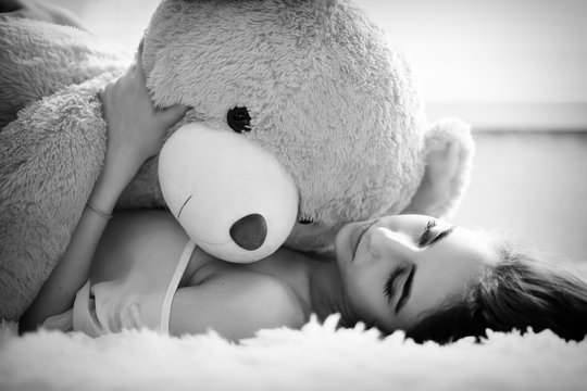 girl lying with teddy bear