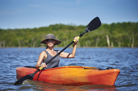A Young Woman Paddling A Kayak