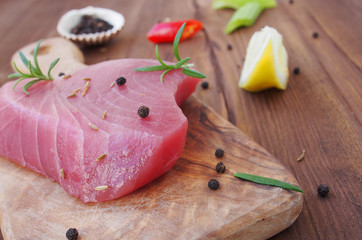 Fresh and raw tuna steak with chili peppers and olive oil