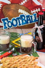 Glasses of beer and tray with garlic cheese breadsticks on the table for football game party.
