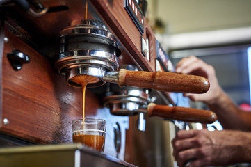 a person making espresso at a coffee shop