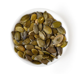 Bowl of pumpkin seeds isolated on white, from above