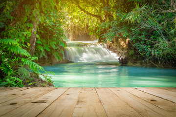 Wood table and Kuang Si waterfalls in Luang Prabang, Laos.