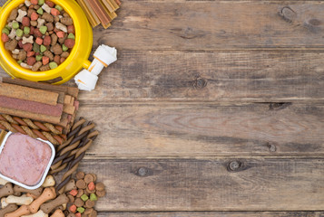Dog food selection on wooden background with copy space, top view