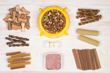 Dog food selection on white, wooden background, top view 