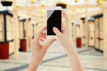Female hands shows mobile smart phone, blurred background