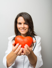 Woman doctor holding a red heart