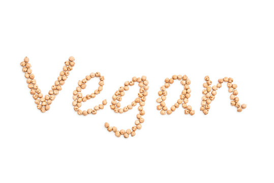Wort Vegan als Schriftzug aus Kichererbsen auf wei&szlig;em Hintergrund freigestellt