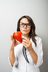 Woman doctor holding a red heart