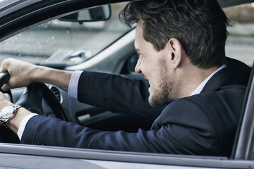 Businessman driving angry in car