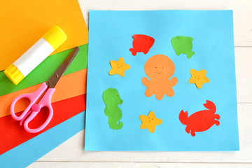 Paper applique with sea animals and fishes. Art lesson in kindergarten. Paper sea animals - octopus, fish, starfish, seahorse, crab. Kids crafts. Sheets of colored paper, scissors, glue 