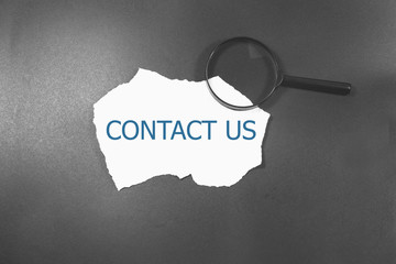 contact us word written under brown torn paper