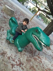 公園で恐竜に乗る子供
