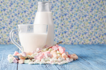 Pastel colored candy in a pile on a blue surface
