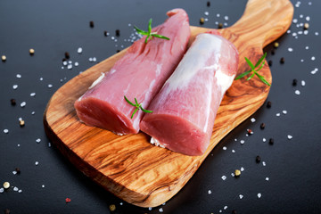 Fresh Raw pork tenderloin on wooden board .ready to cook